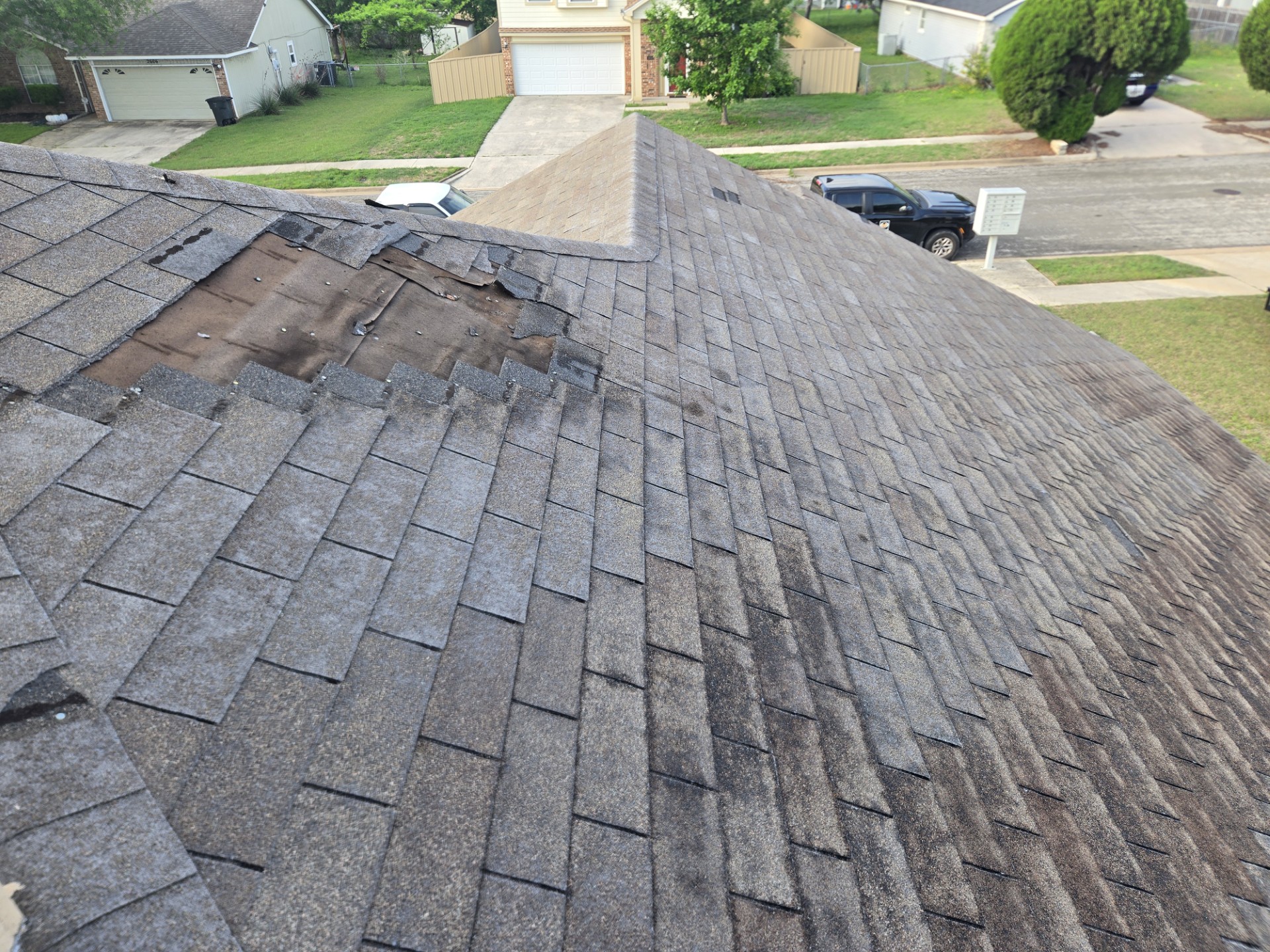 Real customer roof — missing shingles, exposed underlayment, granule loss and storm damage before Hi-Tech Roof Solutions
